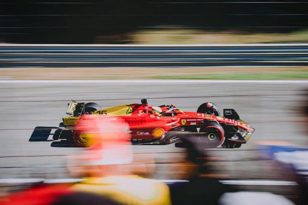 Ein Ferrari-Rennwagen fährt auf der Strecke, mit Fans im Vordergrund