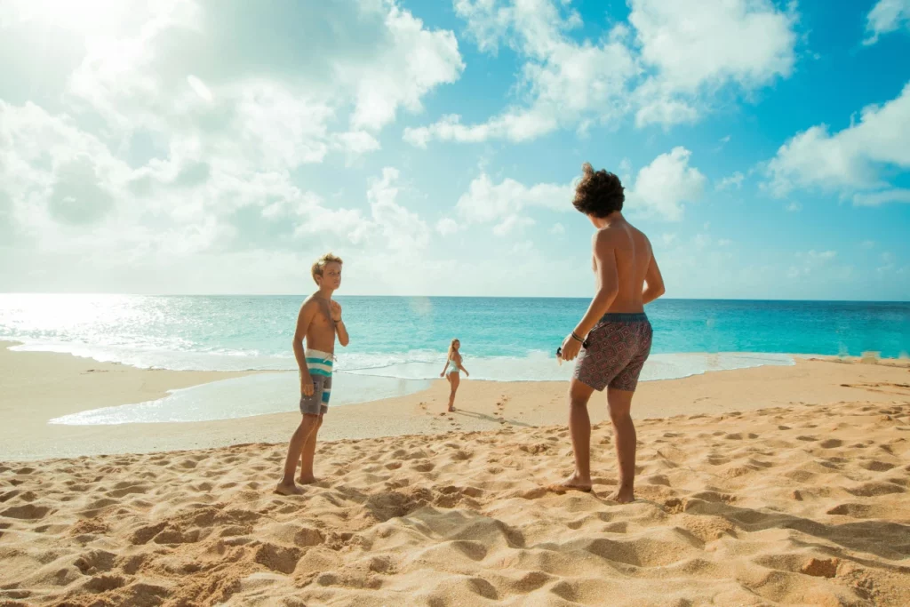 Kinder spielen am Strand auf einer Familienreise auf die Malediven